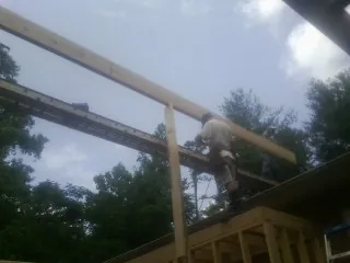 Carpenter setting a ridge beam over a new addition frame — Ice Dam Removal by Roofing Brothers in Stilwell