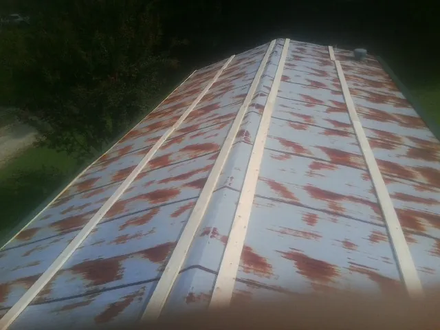 Rusted metal roof panels with new wood purlins before replacement — Storm Damage Roof Repair in Stilwell by Roofing Brothers