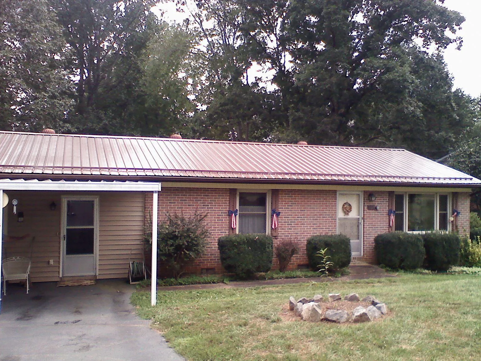 Bronze metal roof and carport on a brick ranch home in Stilwell