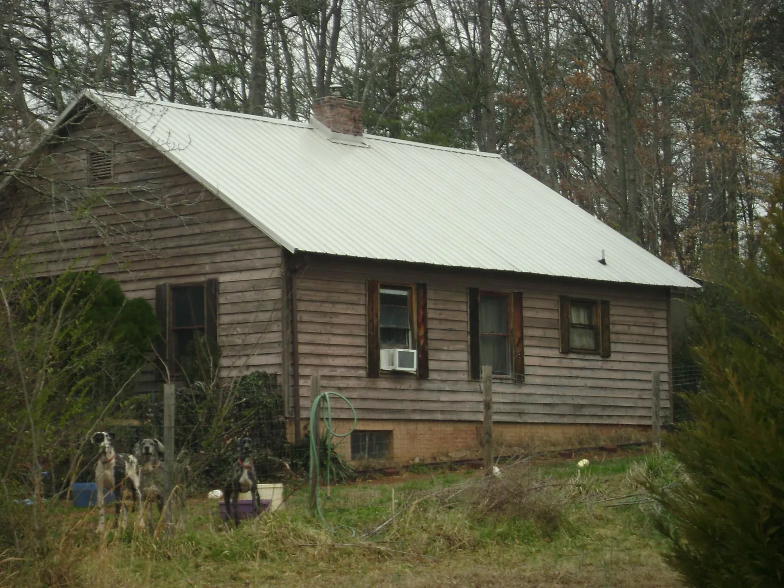 White metal roof on an old wood sided farmhouse, from a Asphalt Shingle Roof Repair job in Stilwell